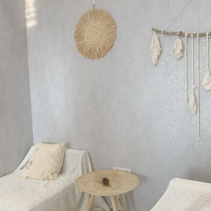 Dettaglio specchio da parete in rafia boho con frange in cotone macramè fatte a mano