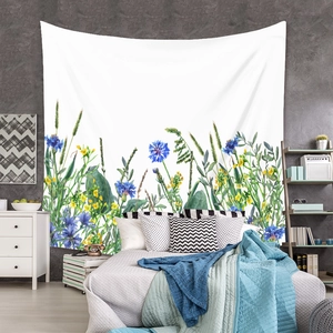 Detailed view of bohemian floral tapestry with blue cornflowers and wildflowers on gray wall
