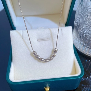 Macro shot of silver titanium steel bead necklace in a dark green jewelry box
