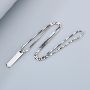Macro view of polished silver stainless steel rectangular bar pendant and box chain