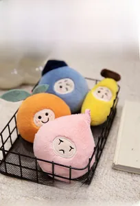 Cute fruit plush dolls in a black metal basket on a cozy beige rug background