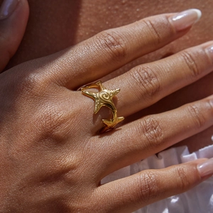 Detail of adjustable gold starfish ring on model with soft summer lighting