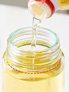 Macro detail of large opening glass oil dispenser showing easy pouring and wide bottleneck