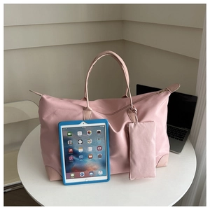 Pink waterproof oxford tote bag with matching pouch shown on a table for size scale