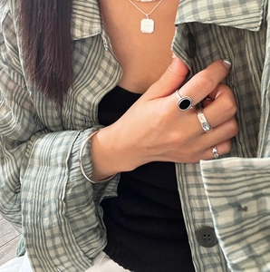 Close-up of minimalist silver jewelry set including PARIS pendant and bear ring style