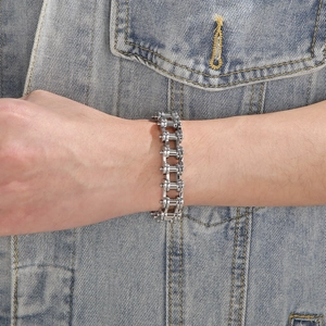 Gros plan d'un bracelet de chaîne de vélo industriel en argent de 13mm sur denim
