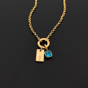 Collar de acero de titanio dorado con letra I grabada y gema azul cuadrada