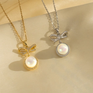 Elegant gold and silver bow necklaces with micro-set pearls on champagne silk background