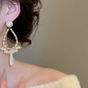 Detail view of French vintage style long pearl tassel earrings on a female model
