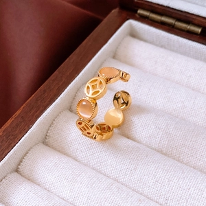Detail of gold coin ring featuring a cat-eye stone inlay in a luxury jewelry box