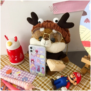 Detail of cute Shiba Inu plush doll wearing reindeer hat and holding a clear phone case