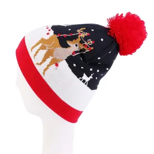 Detail of winter Christmas beanie featuring reindeer jacquard and a large red pompom