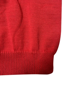Detalle de un suéter de punto rojo con dobladillo acanalado y textura de punto fina