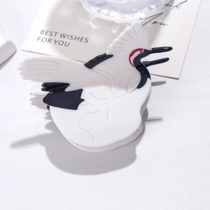 Elegant crane bird acetate hair claw clip with black white and red accents on white desk