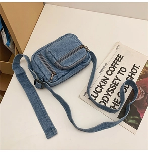 Detail view of the retro denim crossbody bag showing multiple pockets and wide strap
