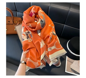 Close-up of orange equestrian pattern scarf with fringe, featuring soft cashmere-like texture