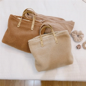 Macro view of plush lamb wool tote bag texture with reinforced faux leather handle