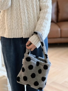 Détail du sac à main en peluche grise à pois noirs avec texture douce en polaire