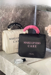 Close-up of large makeup bags with pearl accents and stylish contrasting handles