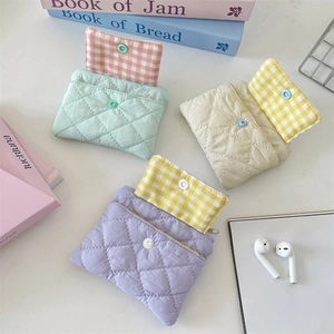 Detail view of quilted card holder wallets with snap buttons and plaid pattern lining