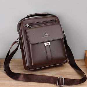 Retro brown leather messenger bag for men with adjustable strap on a wooden surface