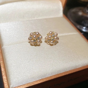 Detail of floral earrings with pearls and rhinestones on a silk lining background