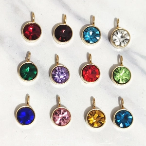 Douze pendentifs pierre de naissance de 6mm avec bordure dorée sur fond de marbre chic