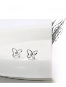 Macro shot of high quality silver butterfly stud earrings with minimalist metal luster