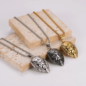 Three lion head pendant necklaces in gold, silver and gun black on stone props
