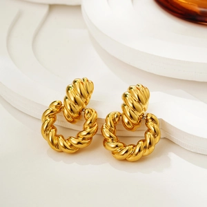 Orecchini a cerchio intrecciati in oro 18K su supporti geometrici bianchi