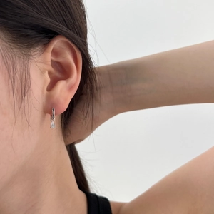 Detail view of S925 silver earring with pear-shaped zircon pendant on a female model