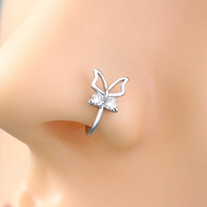 Macro shot of silver bow-shaped non-piercing nose ring with sparkling clear gemstones