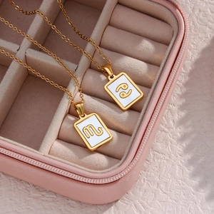 Gold zodiac necklace with shell Scorpio and Cancer pendants in a pink jewelry gift box