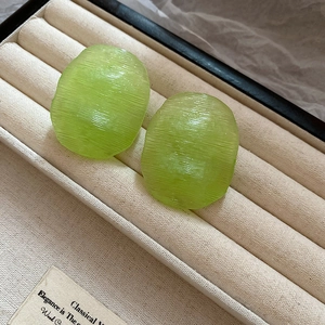 Macro shot of light green resin hoop earrings with textured finish in a jewelry box