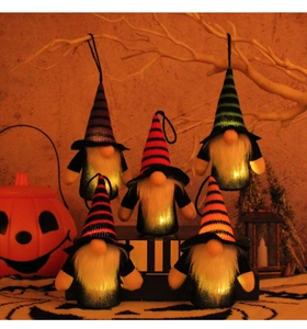 Detail of five glowing Halloween gnomes with colorful striped hats and warm LED lights