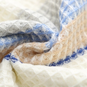 Macro shot of honeycomb waffle weave cotton towel with blue and beige textured details