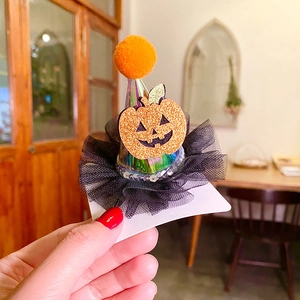 Close-up of mini Halloween party hat hair clip featuring glitter pumpkin and mesh details