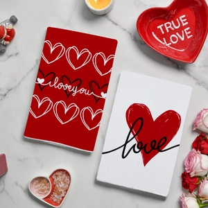 Red heart patterned Valentine cards on white marble with roses and candles