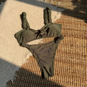 Detailed view of olive green bikini with starfish accent and pleated ribbed fabric texture