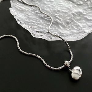Polished silver bean pendant on a sleek box chain for a minimalist necklace style