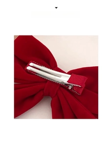Close-up of the red velvet bow hair clip showing the metal alligator clip detail