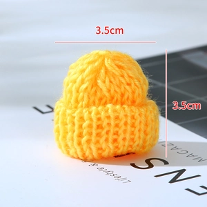 Close-up of yellow mini knitted Christmas hat with 3.5cm dimensions on a magazine background