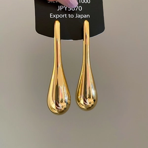 Detailed view of teardrop earrings with polished gold finish on Silver 1000 display card