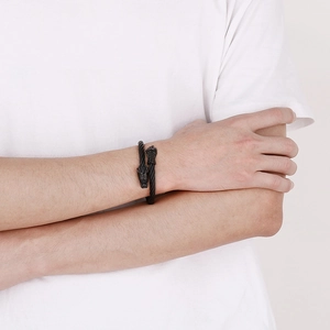 Gros plan sur un bracelet punk à tête de dragon noir porté par un homme