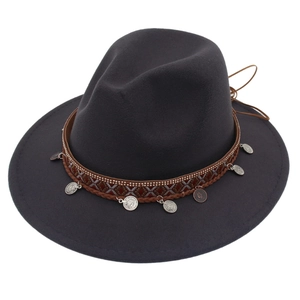 Detail of grey wool fedora hat with ethnic brown leather band and silver coin pendants