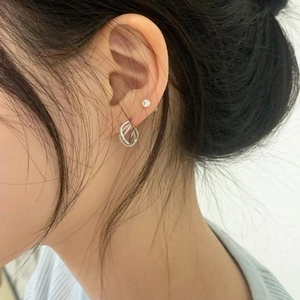 Close-up of 925 sterling silver rope hoop earring and tiny white zircon stud on ear