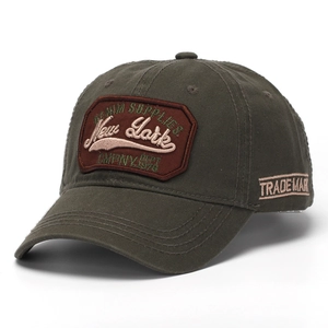 Detailed close-up of New York vintage patch embroidery on olive green cotton baseball cap