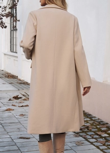 Rear view of a beige long wool blend coat featuring a clean minimalist silhouette outdoors