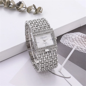 Macro detail of silver square quartz watch with rhinestones on a botanical background