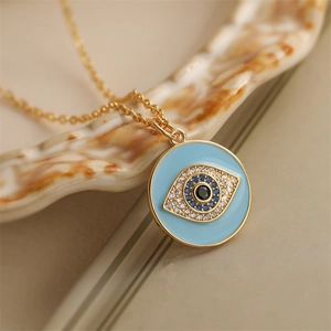 Golden necklace with blue enamel evil eye pendant featuring micro-set sparkling crystals